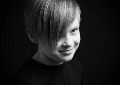 A black and white studio portrait of a boy